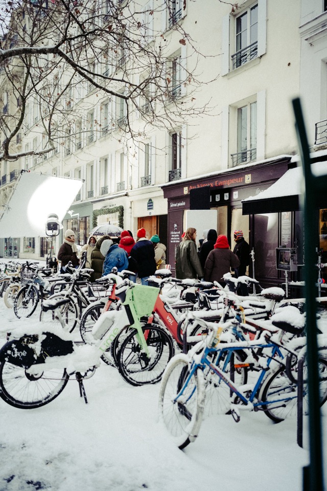 Snow-covered bikes at a rack
