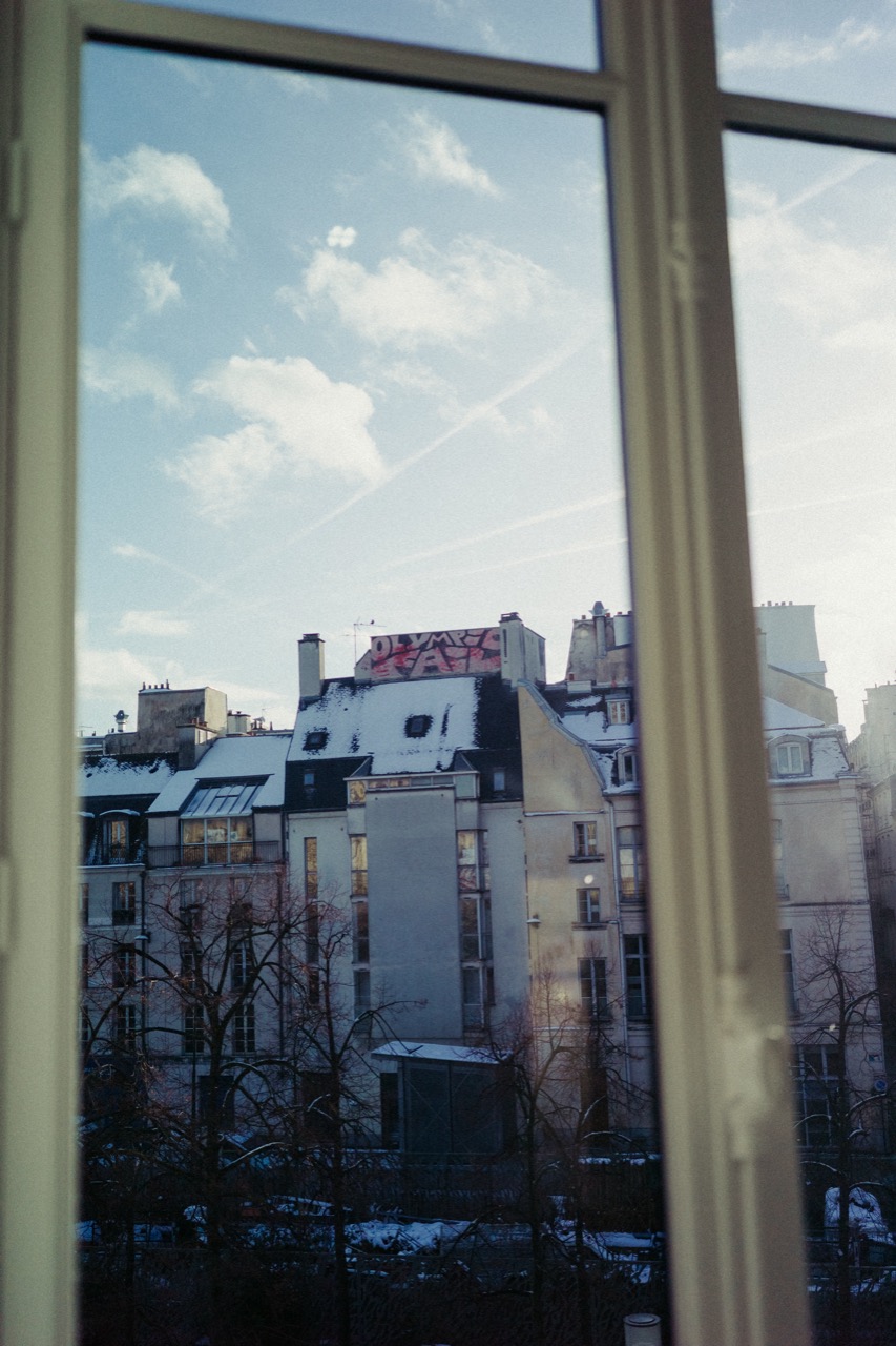 Paris rooftops and graffiti seen through a window