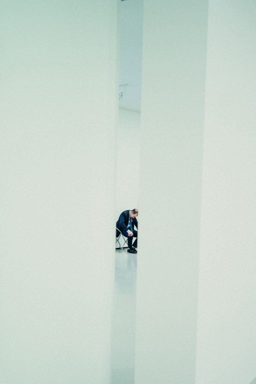 Person seen through gap in white wall