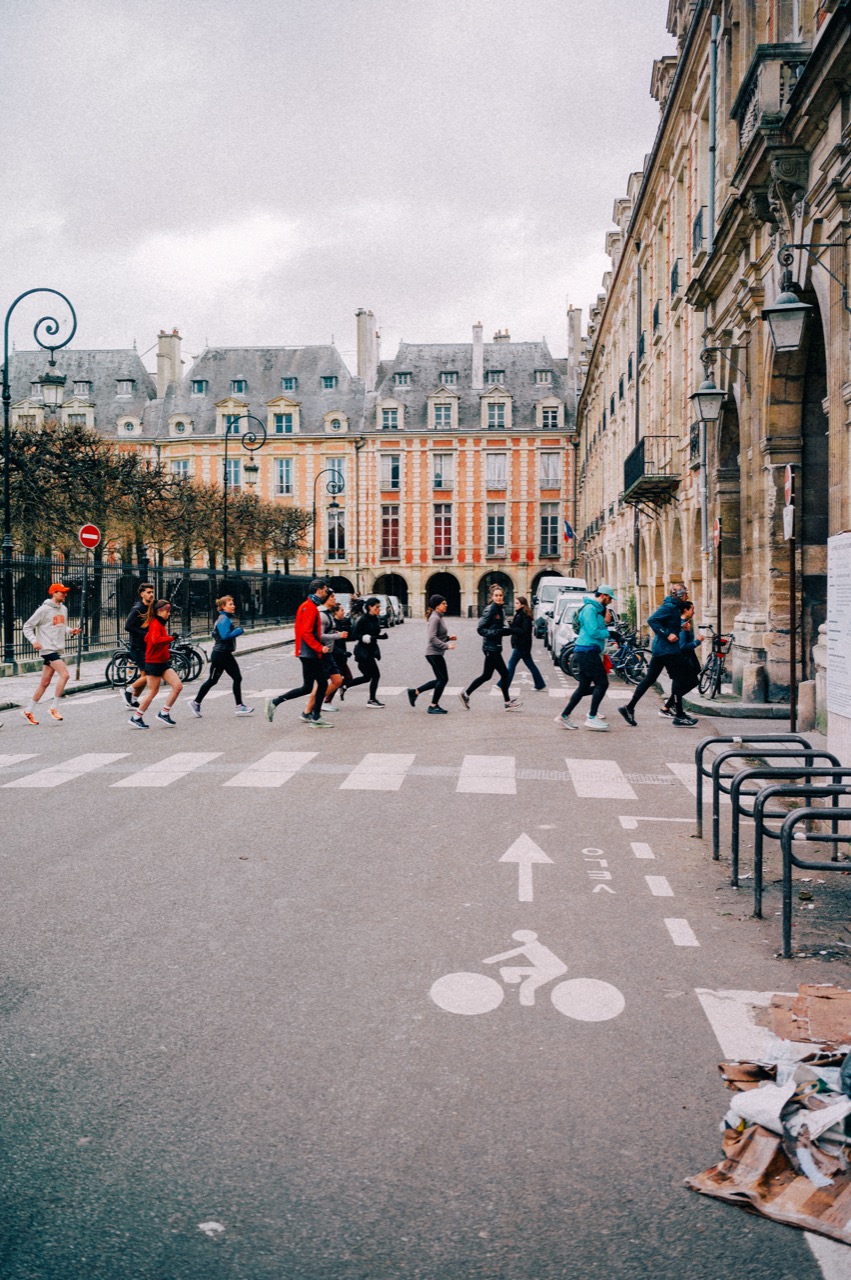 Running group crossing at Place des Vosges