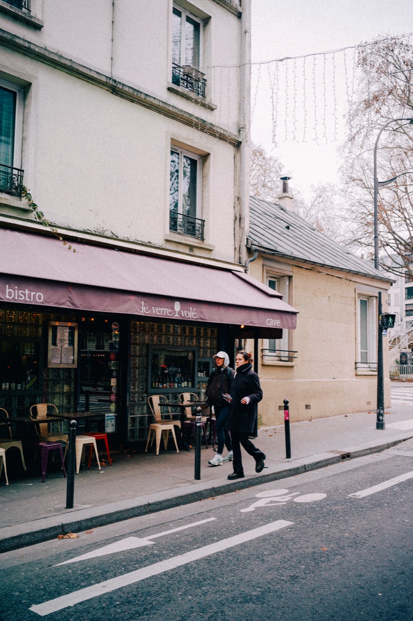 Couple walking past Le Verre Volé bistro